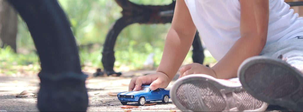 young toddler playing with toy car