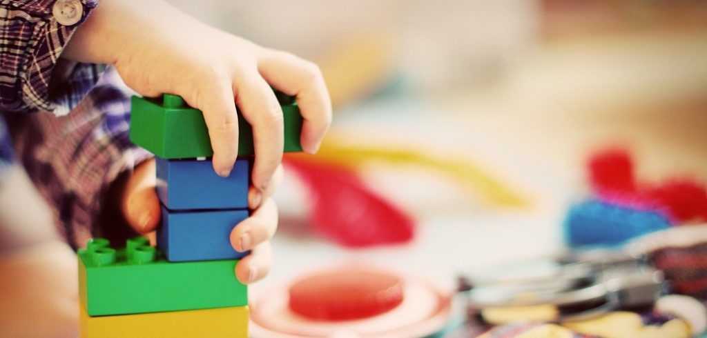 child's hands and building blocks