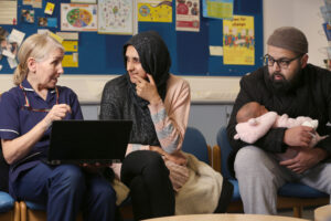 A staff nurse with parents and their baby, talking