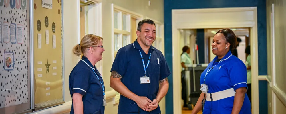 Members of staff chatting in a corridor