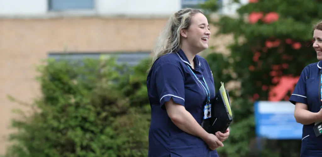 Two members of staff talking outside