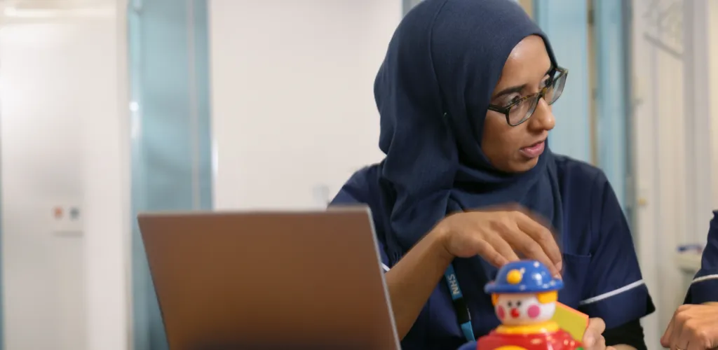 Two female members of staff talking with a computer