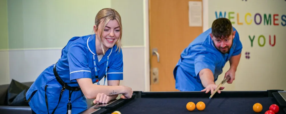 Members of staff playing pool