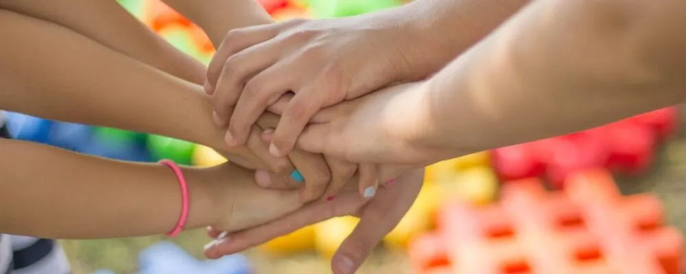 Photograph of children's hands one on top of another indicating solidarity