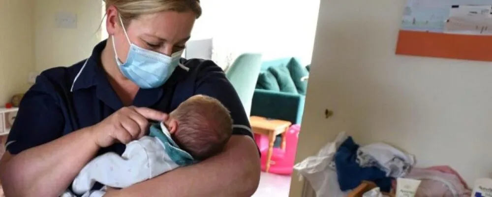 Photograph of a health visitor with a baby